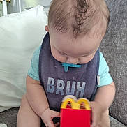 Liam joined the competition — help win amazing prizes! baby, infant, pacifier, bib, happy_meal, toy, couch, indoor, child, clothing, foot, hand, sitting, door, knob, curly_hair, smile, face, head, relaxed