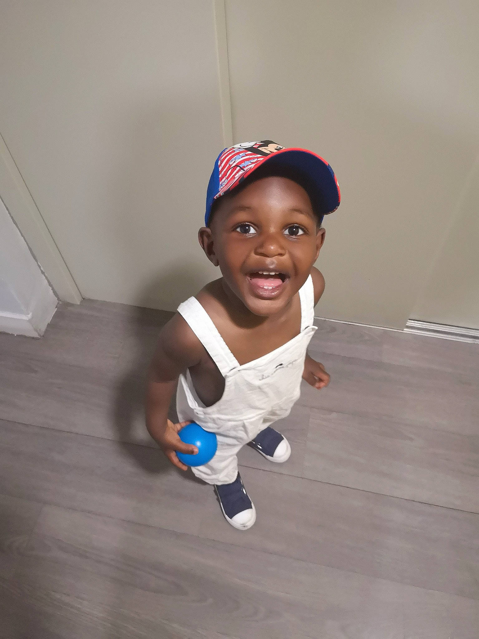Nolan-élie participe au concours pour gagner de l'argent avec cette photo : baby, baby_toddler_clothing, baseball_cap, cap, elbow, electric_blue, flash_photography, floor, flooring, fun, gesture, glove, happy, hardwood, joy, person, sleeve, smile, t_shirt, thumb