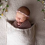 Jenna participe au concours pour gagner de l'argent avec cette photo : newborn, baby, sleeping, blanket, headband, floral, wrapped, cozy, soft_texture, peaceful, indoors, portrait, child, cute, infant, resting, wrapped_in_blanket, greenery, decorative, tender