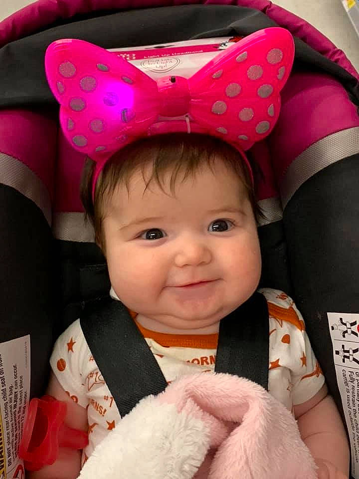 Remington is registered to the contest to win money with this photo: baby, car_seat, cheek, child, ear, fashion_accessory, hair_accessory, headgear, person, pink, skin, toddler