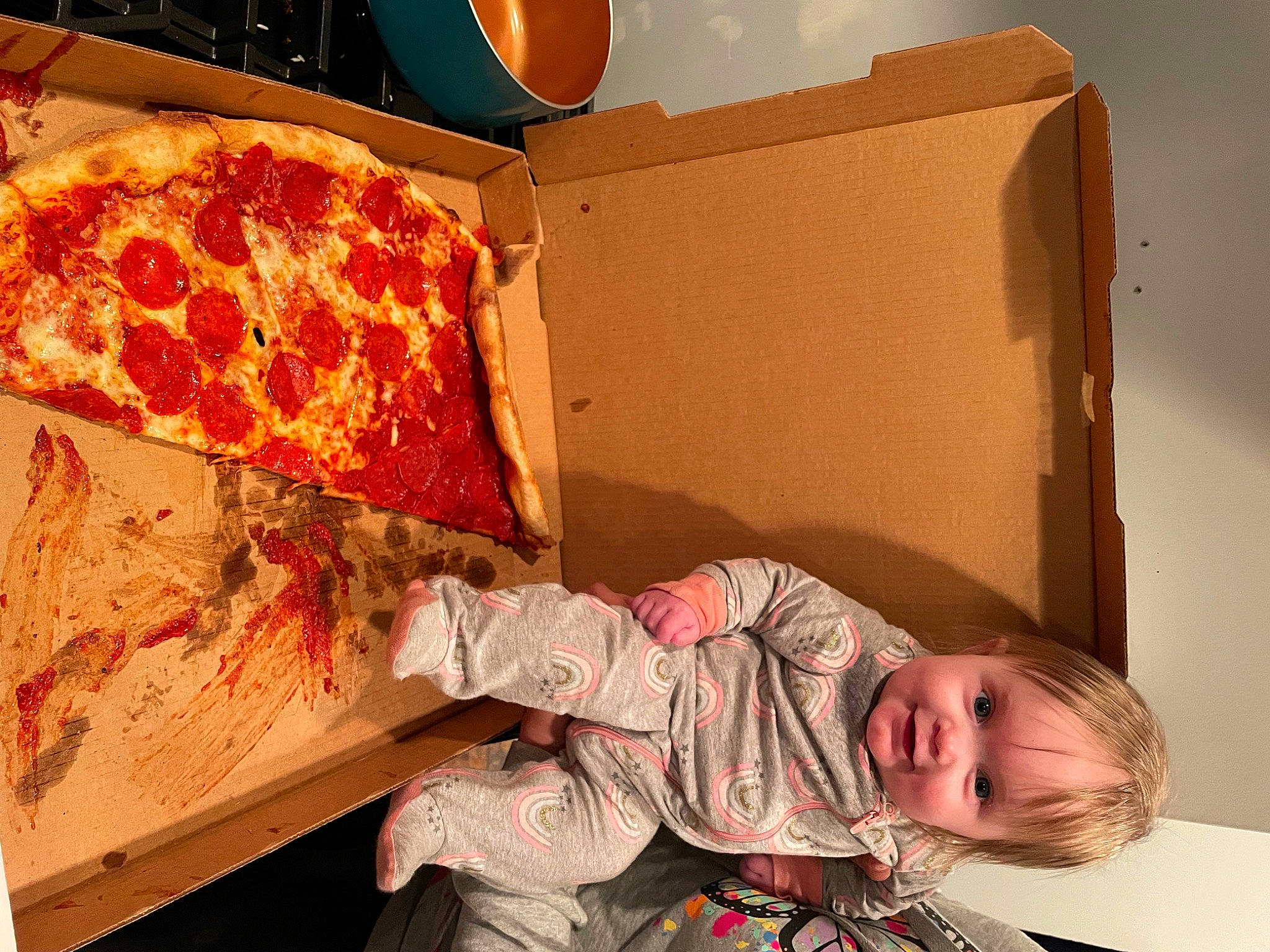 Maleah is registered to the contest to win money with this photo: art, baby, baby_toddler_clothing, box, comfort_food, cuisine, fast_food, ingredient, italian_food, junk_food, linens, orange, pattern, person, pizza, room, shipping_box, sitting, toddler, visual_arts