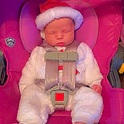 Anna is registered to the contest to win money with this photo: baby, infant, sleeping, car_seat, pink, holiday_hat, santa_hat, white_clothing, cute, child, straps, safety_harness, foot, indoor, seat, adorable, peaceful, newborn, soft_texture, holiday