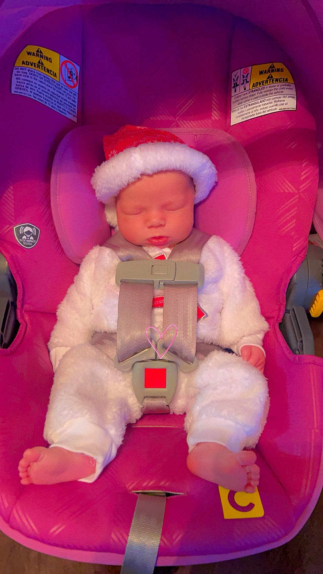Anna is registered to the contest to win money with this photo: baby, infant, sleeping, car_seat, pink, holiday_hat, santa_hat, white_clothing, cute, child, straps, safety_harness, foot, indoor, seat, adorable, peaceful, newborn, soft_texture, holiday