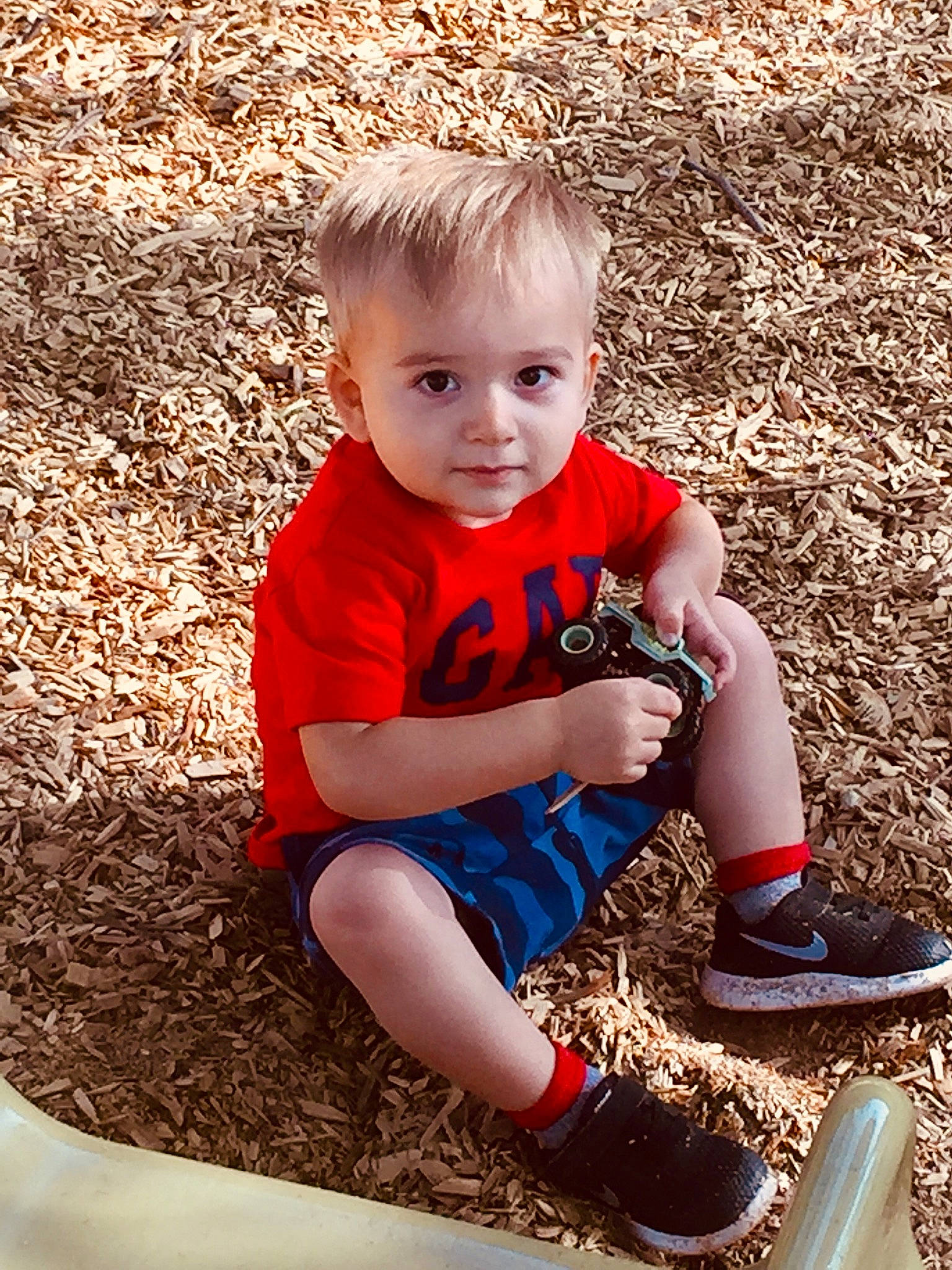 Leroy is registered to the contest to win money with this photo: blond, child, child_model, footwear, fun, leg, person, play, red, shoe, sitting, smile, soil, toddler