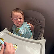 Cooper joined the competition — help win amazing prizes! baby, high_chair, food, bib, green_food, hand, feeding, expression, face, messy, indoor, child, person, meal, tray, clothing, cute, funny, tongue, dining