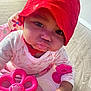baby, child, red_hat, pink_toy, walker, pout, curious, indoor, flooring, playtime, cute, infant, clothing, face, hand, person, closeup, expression, headwear, toy