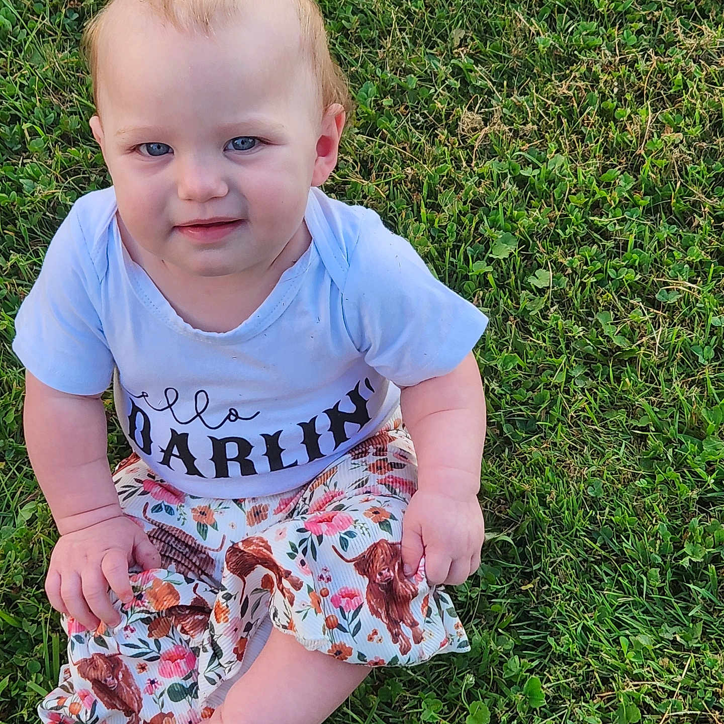 Rowyn is registered to the contest to win money with this photo: baby, barefoot, blue_eyes, child, clothing, crossed_legs, cute, daylight, dog_print, expression, grass, nature, outdoor, person, portrait, shirt, short_hair, sitting, skirt, young_child