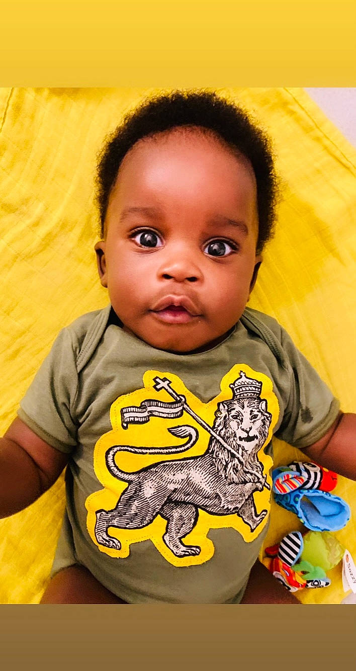 Médoune a rejoint le concours — aidez-le/la à gagner de superbes lots ! baby, baby_toddler_clothing, cheek, chin, facial_expression, forehead, happy, head, human, iris, mouth, nose, orange, organ, person, product, skin, sleeve, smile, toddler