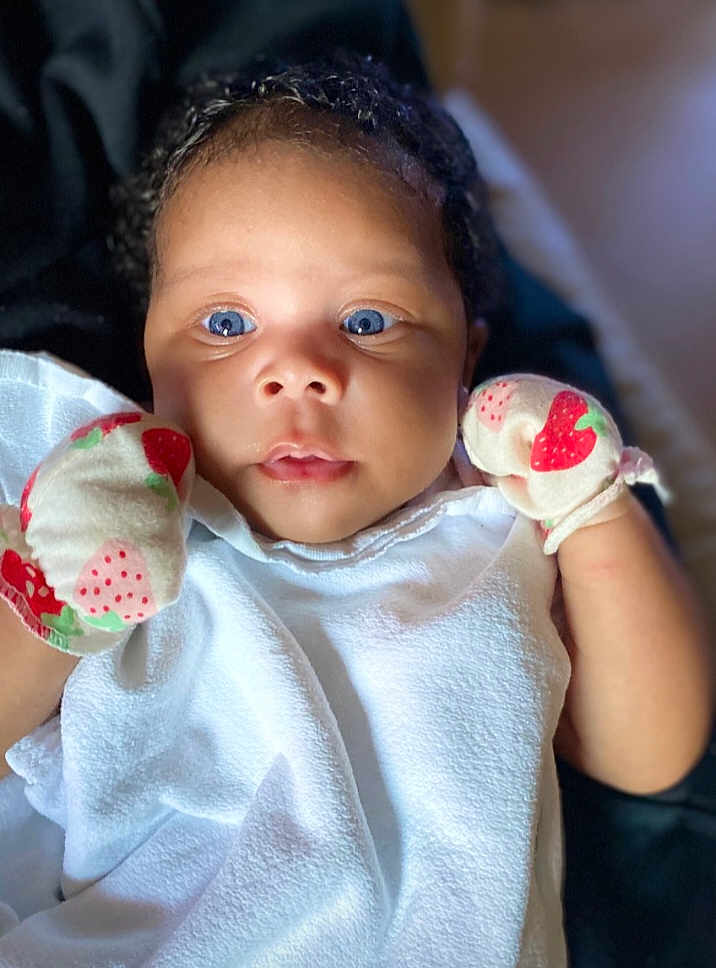 Jream joined the competition — help win amazing prizes! adorable, baby, blanket, blue_eyes, child, closeup, curly_hair, cute, expression, face, indoor, infant, mittens, newborn, portrait, skin, small_hands, soft_light, strawberry_pattern, white_clothing