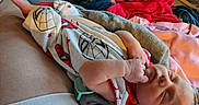 Elliott is registered to the contest to win money with this photo: newborn, baby, sleeping, blanket, spiderman, clothing, hand, foot, soft_texture, indoor, person, rest, comfort, cute, infant, portrait, colorful, fabric, cozy, relaxation