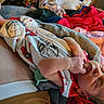 newborn, baby, sleeping, blanket, spiderman, clothing, hand, foot, soft_texture, indoor, person, rest, comfort, cute, infant, portrait, colorful, fabric, cozy, relaxation