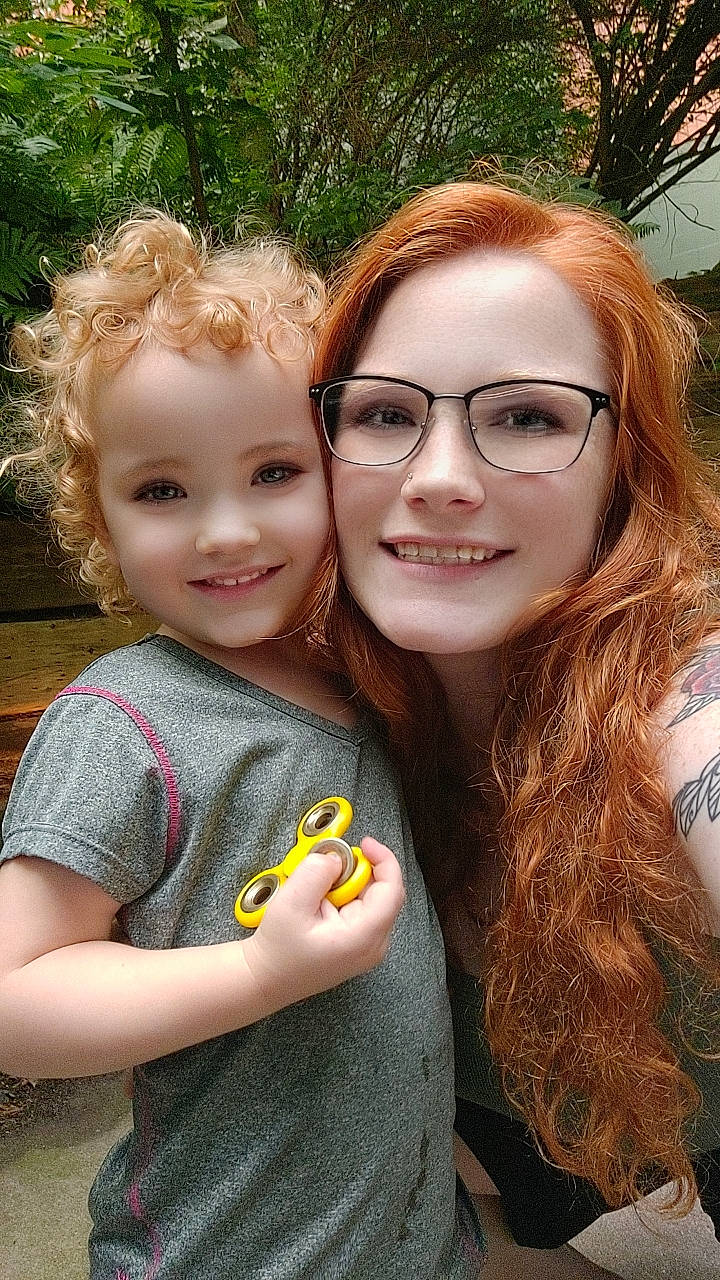 Amelia is registered to the contest to win money with this photo: chin, cool, eye, face, gesture, glasses, grass, hair, happy, head, iris, joy, leaf, lip, people_in_nature, person, plant, skin, smile, social_group