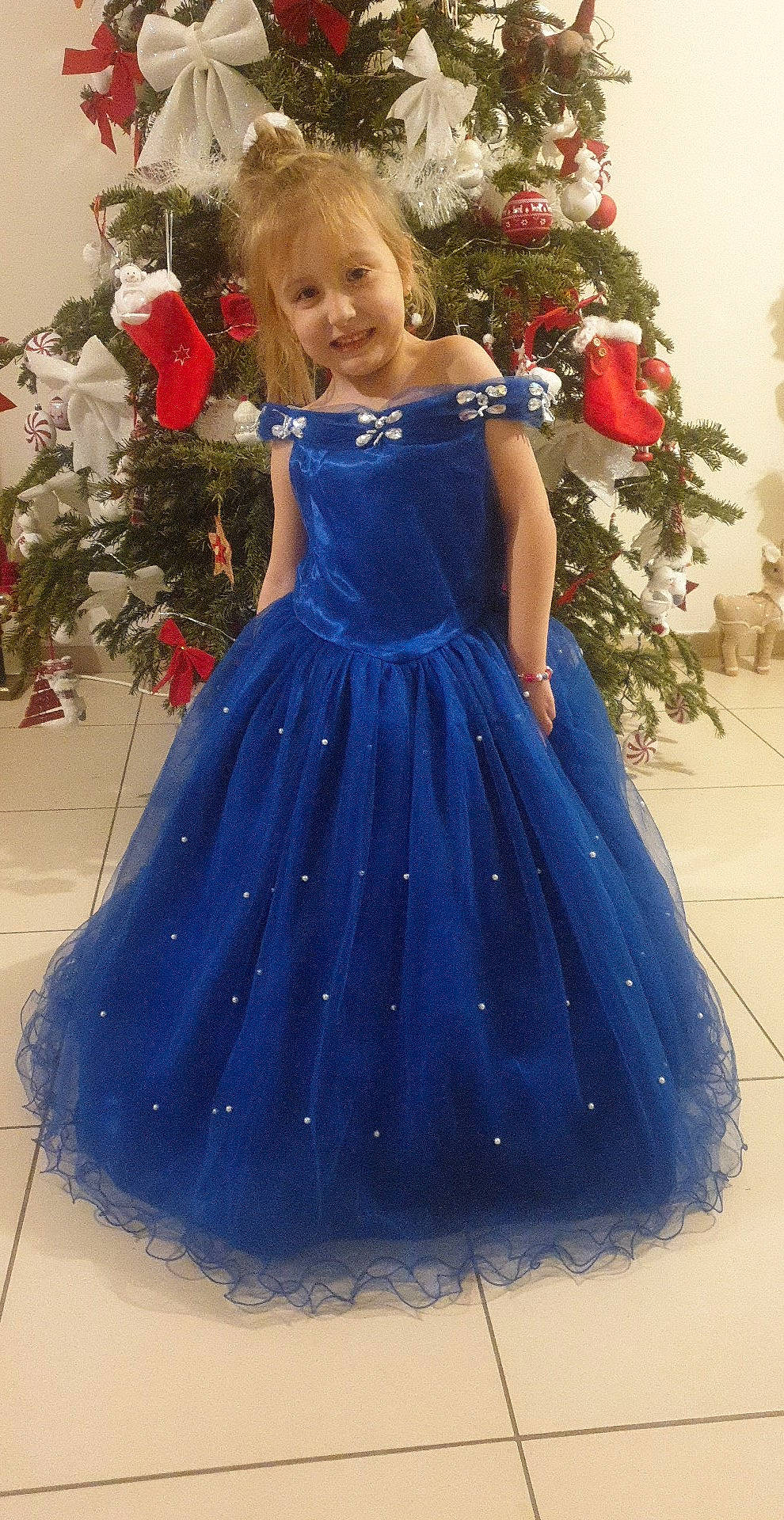 Maellys a rejoint le concours — aidez-le/la à gagner de superbes lots ! arm, bridal_party_dress, christmas_ornament, day_dress, dress, electric_blue, face, facial_expression, fashion_design, happy, joy, long_hair, one_piece_garment, person, plant, red, shoulder, sleeve, standing, tree