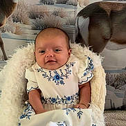 Willow is registered to the contest to win money with this photo: baby, child, infant, dress, white, blue, floral, chair, fluffy, fur, deer, animal, winter, forest, background, smile, portrait, indoor, cute, cozy