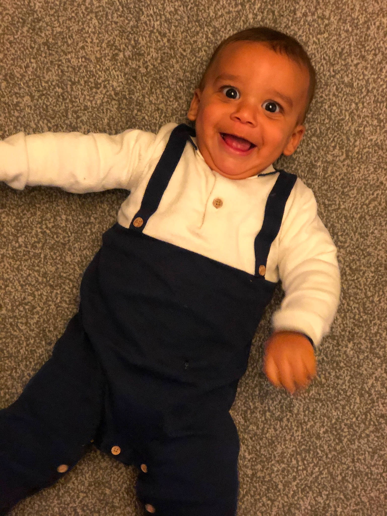 Kassius is registered to the contest to win money with this photo: arm, baby, cheek, child, finger, formal_wear, joy, outerwear, person, skin, sleeve, smile, standing, suit, t_shirt, thumb, toddler, tuxedo