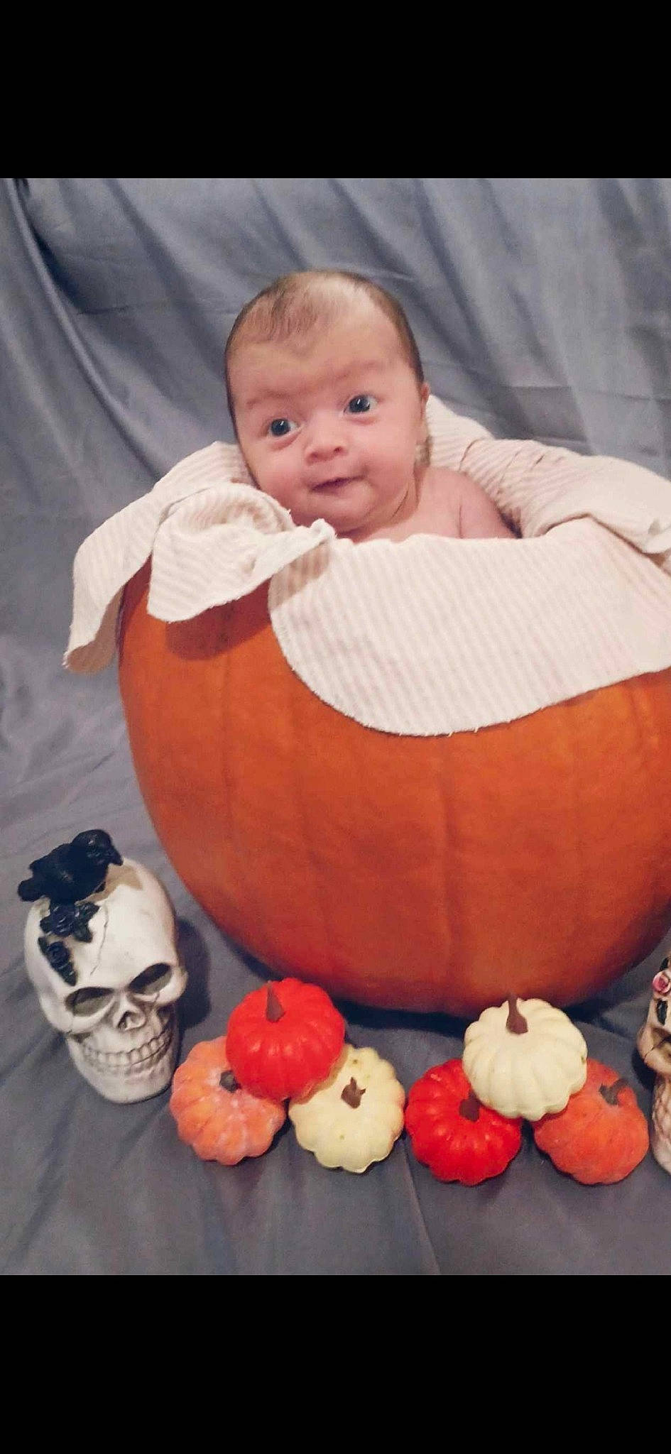 Angela is registered to the contest to win money with this photo: art, baby, baby_products, baby_sleeping, baby_toddler_clothing, calabaza, child, comfort, eye, face, flooring, orange, person, pumpkin, stuffed_toy, textile, toddler, toy, white, winter_squash