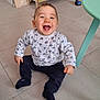 baby, child, smiling, sitting, indoor, floor, toy, table, furniture, happiness, mickey_mouse, clothing, person, cute, playroom, pants, socks, joyful, young, home
