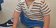 Tyrone a rejoint le concours — aidez-le/la à gagner de superbes lots ! toddler, child, sitting, floor, striped_shirt, blue_shorts, sneakers, nike, sock, indoor, tile_floor, cute, happy, baby, portrait, casual_clothing, one_person, young_child, looking_at_camera, short_hair