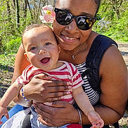 Tyméo participe au concours pour gagner de l'argent avec cette photo : baby, child, woman, smile, sunglasses, flower, outdoor, forest, nature, bench, holding, hug, jeans, striped_shirt, necklace, backpack, portrait, sunlight, happy, foot