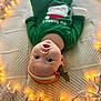 baby, infant, christmas, holiday, green_clothing, headband, holly, red_berries, blanket, fairy_lights, warm_lighting, festive, cute, lying_down, indoor, closeup, portrait, smiling, child, cozy