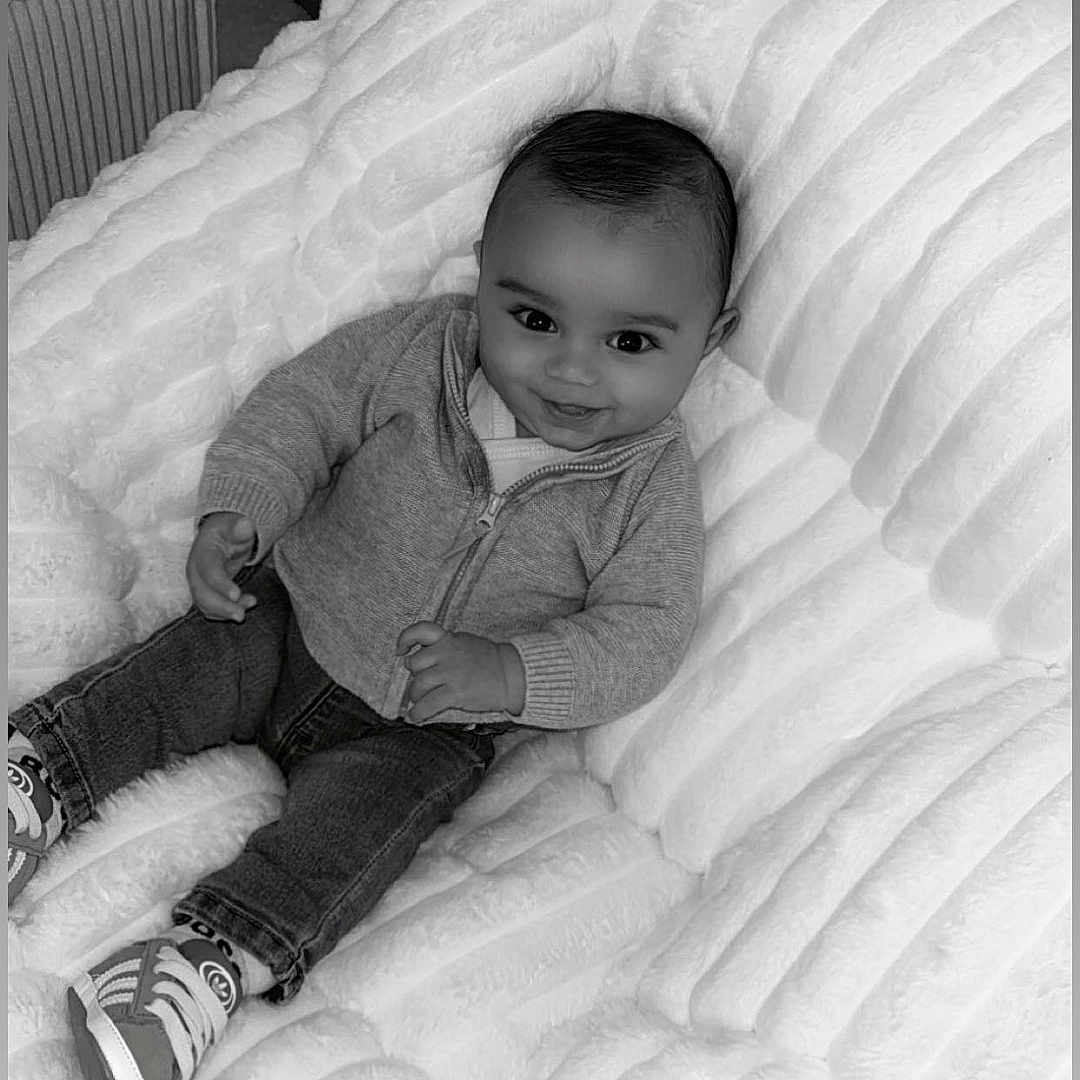 Neyt a rejoint le concours — aidez-le/la à gagner de superbes lots ! baby, black_and_white, child, clothing, couch, cozy, cute, furniture, happy, home, indoor, infant, jeans, person, plush, portrait, shoes, sitting, smile, sweater