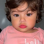 Evelyn is registered to the contest to win money with this photo: toddler, child, portrait, face, curly_hair, pink_shirt, expression, indoor, person, young_child, closeup, baby, cute, eyelashes, skin, clothing, head, looking_at_camera, human, casual