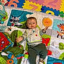 Sandro participe au concours pour gagner de l'argent avec cette photo : baby, child, playmat, toy, bib, sneakers, colorful, numbers, floor, indoor, smile, arm, hand, clothing, infant, pattern, animal_print, playtime, cute, happy