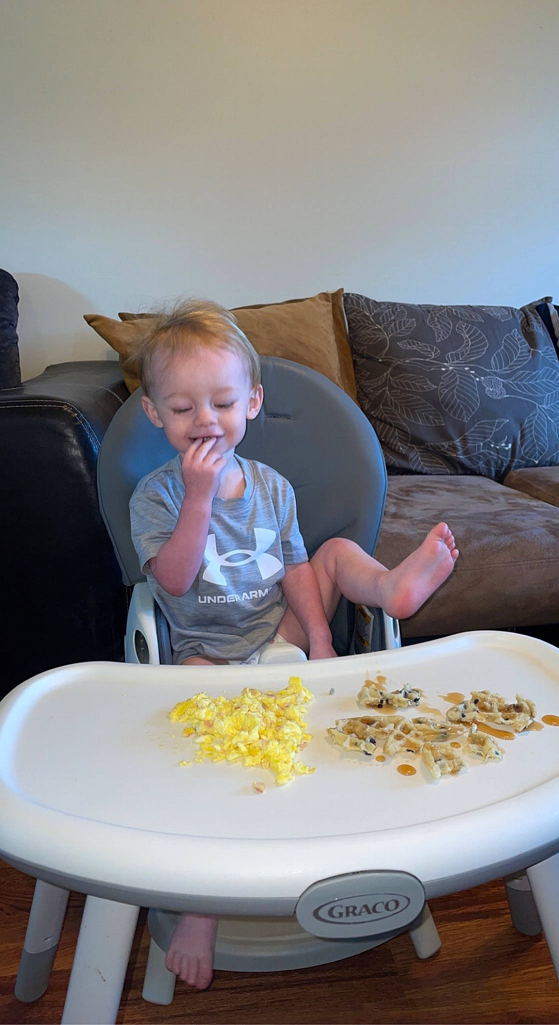 Hendrix is registered to the contest to win money with this photo: baby, chair, child, comfort, comfort_food, couch, cuisine, dish, face, food, fun, head, ingredient, living_room, person, recipe, room, sharing, sitting, t_shirt