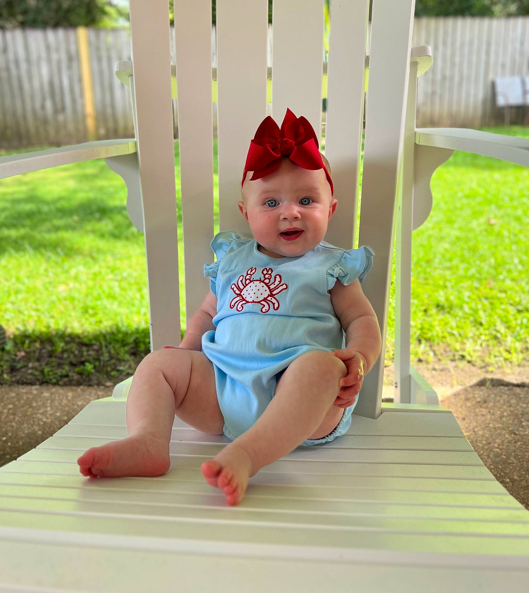 Katie is registered to the contest to win money with this photo: baby, baby_toddler_clothing, child, face, foot, fun, grass, hat, head, headwear, human_leg, knee, leisure, outdoor_furniture, person, recreation, sitting, summer, sun_hat, thigh