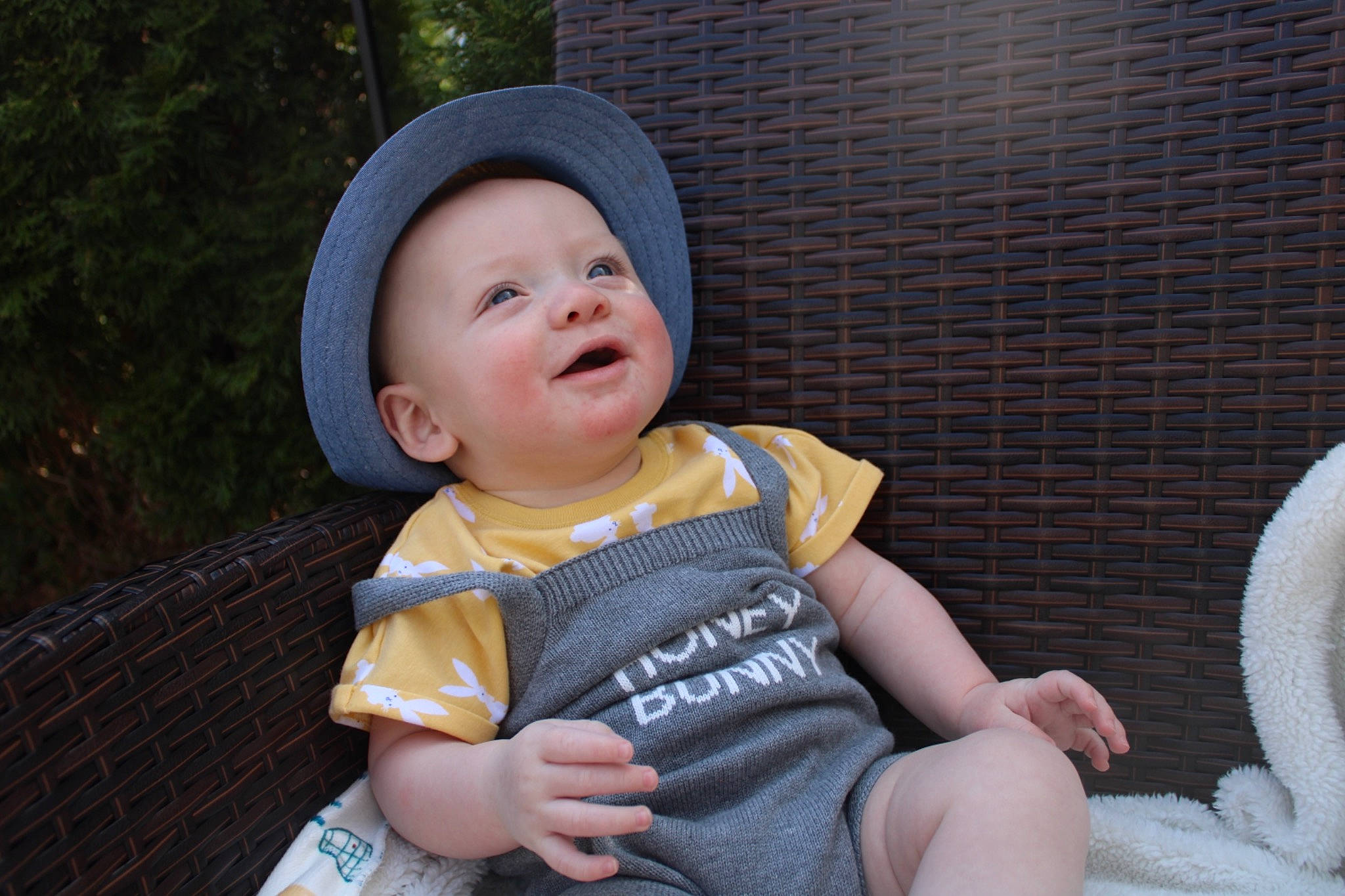 Fisher is registered to the contest to win money with this photo: baby, baby_toddler_clothing, cap, child, costume_hat, facial_expression, fashion_accessory, finger, fun, grass, happy, hat, headwear, person, sitting, skin, smile, sun_hat, thigh, thumb
