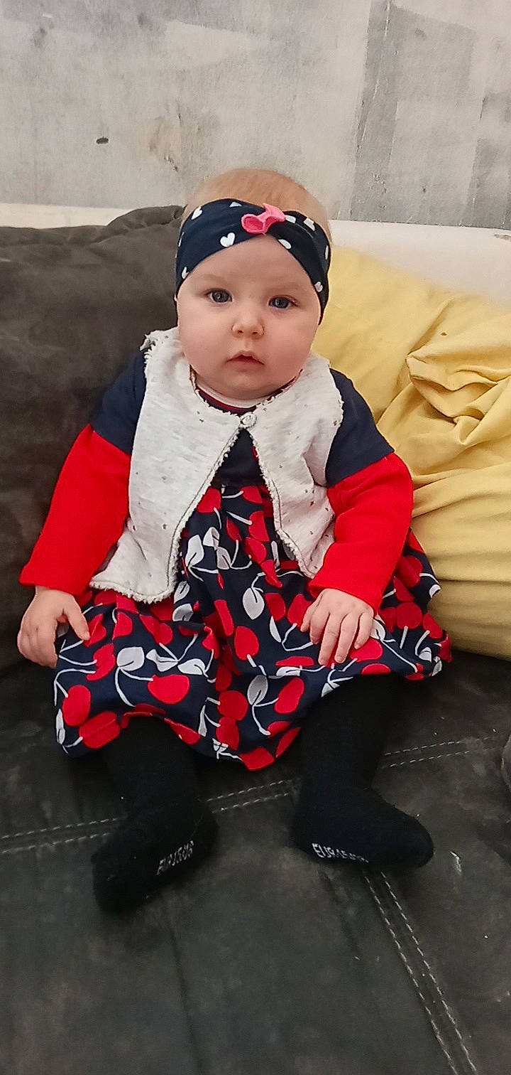 Nathalia a rejoint le concours — aidez-le/la à gagner de superbes lots ! baby, baby_toddler_clothing, beanie, cap, carmine, child, fashion_accessory, fun, happy, headband, headgear, headwear, human_leg, knee, lap, pattern, person, pink, sitting, sleeve