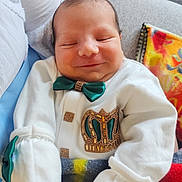 Mohamed Arifan a rejoint le concours — aidez-le/la à gagner de superbes lots ! baby, newborn, smiling, bow_tie, crown, white_clothing, blanket, cozy, portrait, infant, cute, sleepy, resting, soft_fabric, indoor, person, child, closeup, happy, decorative