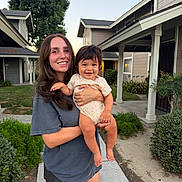Sebastian joined the competition — help win amazing prizes! woman, baby, child, smile, outdoor, suburban, house, greenery, happy, holding, person, casual_clothing, shorts, tshirt, sidewalk, daylight, portrait, family, cute, nature