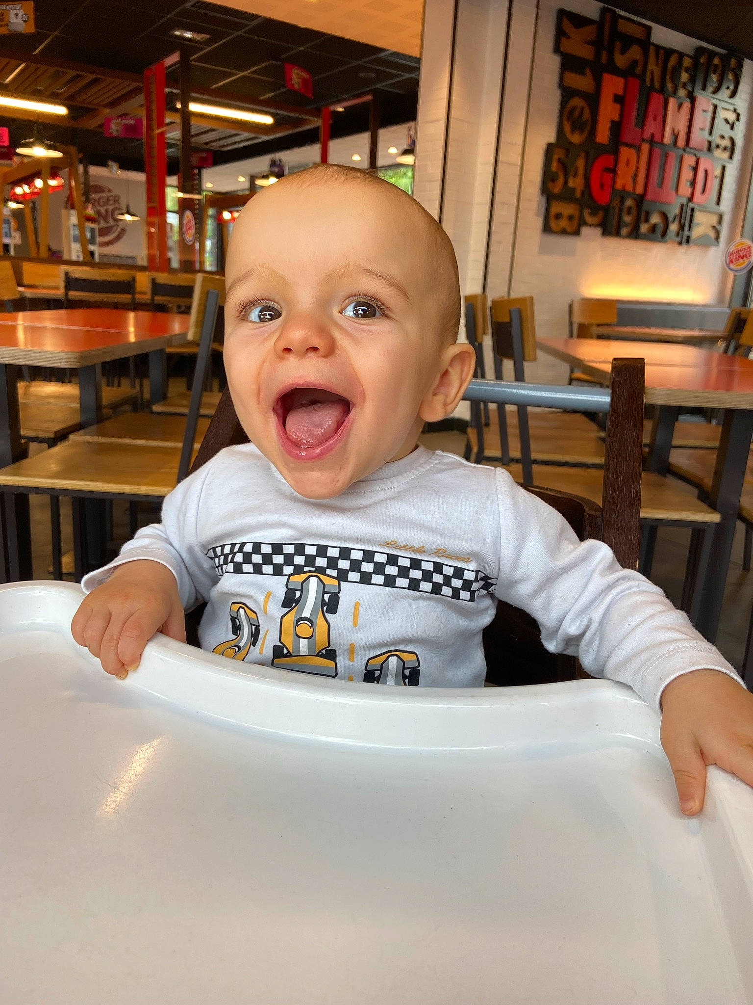 Lissandro a rejoint le concours — aidez-le/la à gagner de superbes lots ! baby, baby_toddler_clothing, chair, cheek, child, fun, happy, humour, laugh, person, picture_frame, room, sitting, sleeve, smile, t_shirt, table, tableware, toddler, top