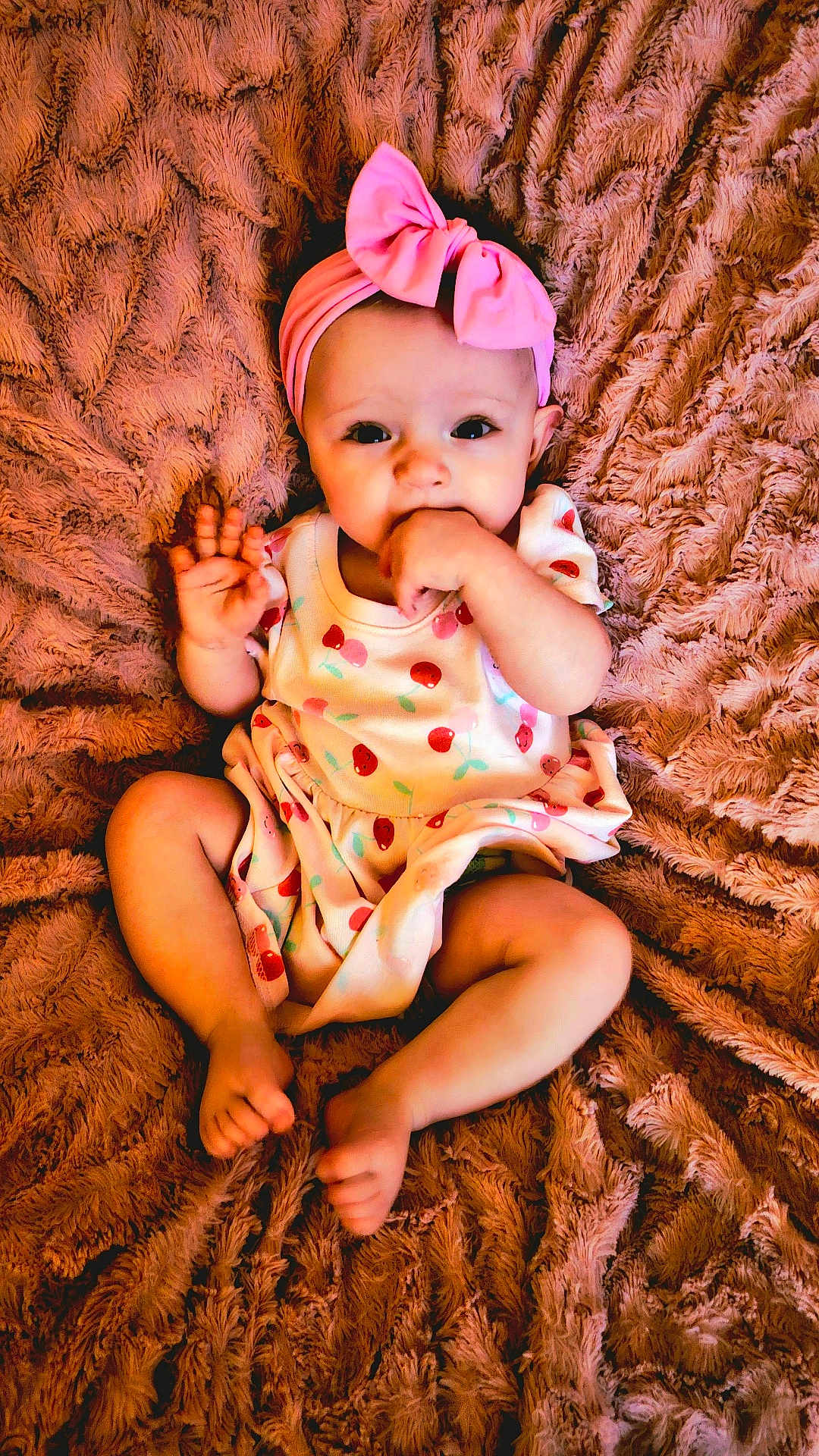 Marley joined the competition — help win amazing prizes! baby, infant, child, pink_bow, hand, fist, waving, dress, cherry_pattern, blanket, texture, soft, cute, sitting, feet, portrait, indoors, person, headband, expression