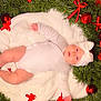 baby, infant, white_onesie, knitted_hat, blanket, wreath, greenery, red_bows, christmas_ornaments, holiday, festive, red_background, cute, chubby_cheeks, lying_down, indoors, soft_texture, decorations, celebration, portrait