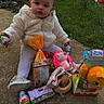 toddler, child, outdoor, grass, toy, plush_toy, candy, snack, jacket, white_clothing, sitting, concrete, cute, face, person, holding, easter, celebration, gift, happy