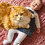 baby, cat, orange_cat, denim_dress, white_tights, pink_rug, fluffy_fur, smiling, cute, indoor, pet, child, lying_down, cozy, adorable, happy, face, feline, comfort, playful
