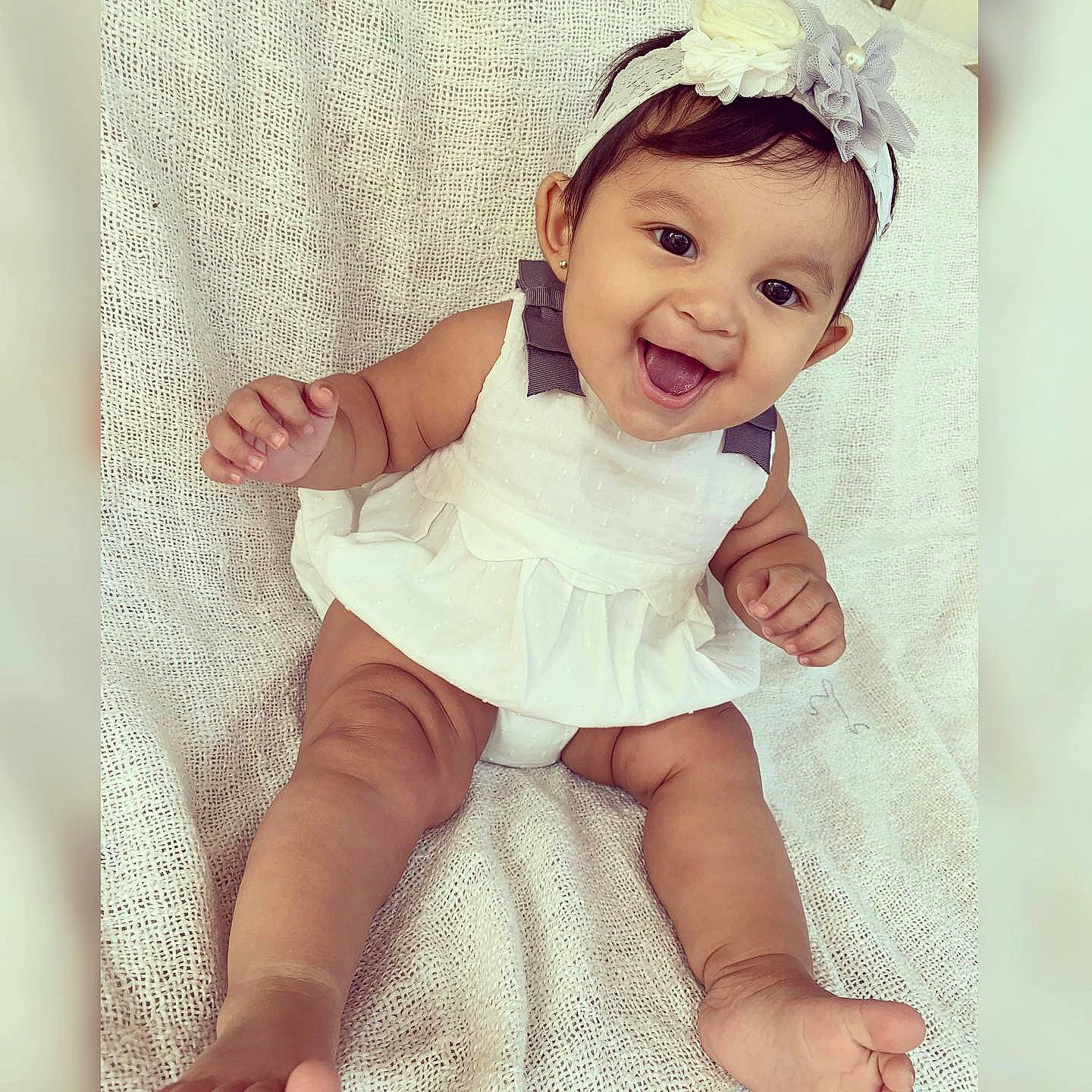 Bria is registered to the contest to win money with this photo: arm, baby, baby_toddler_clothing, beauty, child, dress, eye, face, facial_expression, hair_accessory, hand, happy, head, headpiece, joy, person, pink, product, skin, smile