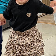 Alma participe au concours pour gagner de l'argent avec cette photo : toddler, child, indoor, fashion, black_top, leopard_print, ruffled_skirt, headband, black_bow, shoes, holding_hands, smiling, cute, floor, cabinet, person, playing, happy, standing, portrait