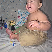 Jared joined the competition — help win amazing prizes! baby, child, paint, paint_splatter, khaki_shorts, bare_chest, handprints, art, creativity, smile, happy, indoors, foot, toes, face, expression, playful, background, sheet, sitting