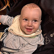 Marlonn participe au concours pour gagner de l'argent avec cette photo : baby, child, smiling, stroller, hoodie, bib, happy, infant, face, person, clothing, cute, seatbelt, indoor, closeup, young_child, joyful, expression, head, baby_toy