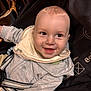 baby, child, smiling, stroller, hoodie, bib, happy, infant, face, person, clothing, cute, seatbelt, indoor, closeup, young_child, joyful, expression, head, baby_toy