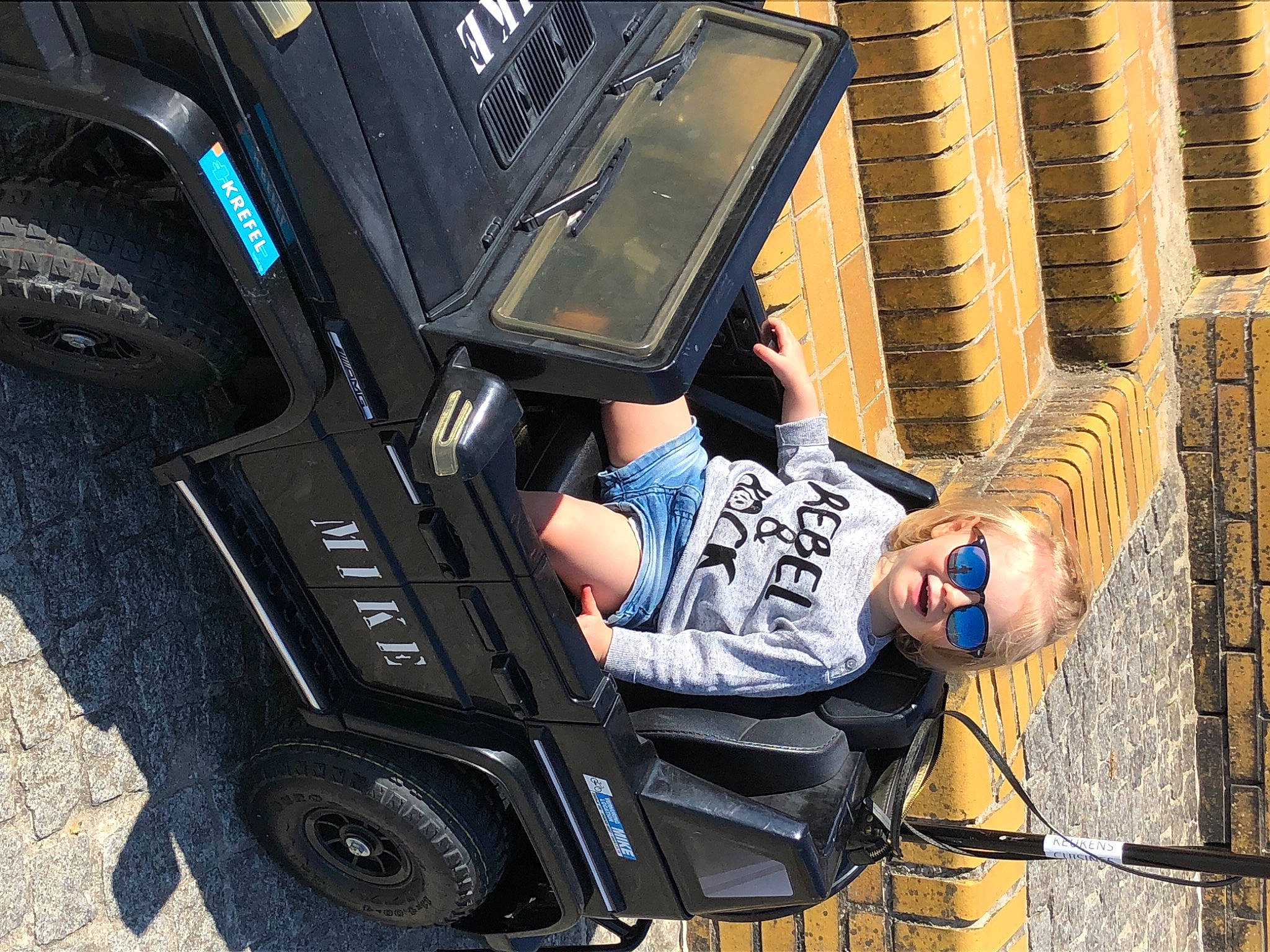 Blake participe au concours pour gagner de l'argent avec cette photo : audio_equipment, auto_part, automotive_design, automotive_exterior, automotive_tire, automotive_wheel_system, baby_carriage, bumper, electric_blue, fender, human_leg, motor_vehicle, person, rolling, sitting, t_shirt, tire, tread, vehicle, vehicle_door