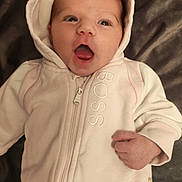 Inaya participe au concours pour gagner de l'argent avec cette photo : baby, bed, bedding, blanket, clothing, cute, eyes, face, hand, hoodie, infant, lying_down, mouth, newborn, pacifier, portrait, skin, soft_texture, surprised_expression, zipper