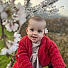 Iris participe au concours pour gagner de l'argent avec cette photo : baby, child, flower, red_jacket, smile, portrait, outdoor, nature, blossom, spring, cute, person, face, happy, young, hand, background, greenery, headwear, toddler