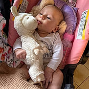 Mazikeen is registered to the contest to win money with this photo: baby, infant, stuffed_animal, plush_toy, baby_bottle, blanket, pink, white, cushion, car_seat, child, cute, soft_toy, indoors, toddler, clothing, holding, pacifier, floor_tile, relaxed