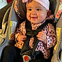Naomi joined the competition — help win amazing prizes! baby, child, car_seat, pink_bow, headband, leopard_print, jacket, black_pants, socks, smiling, happy, infant, seat_belt, indoor, cushion, face, person, cute, young_child, portrait