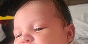 Naomi is registered to the contest to win money with this photo: baby, infant, face, tongue, blanket, indoor, cute, child, newborn, sleepy, soft, chubby_cheeks, person, portrait, wrapped, hand, skin, expression, young, cozy