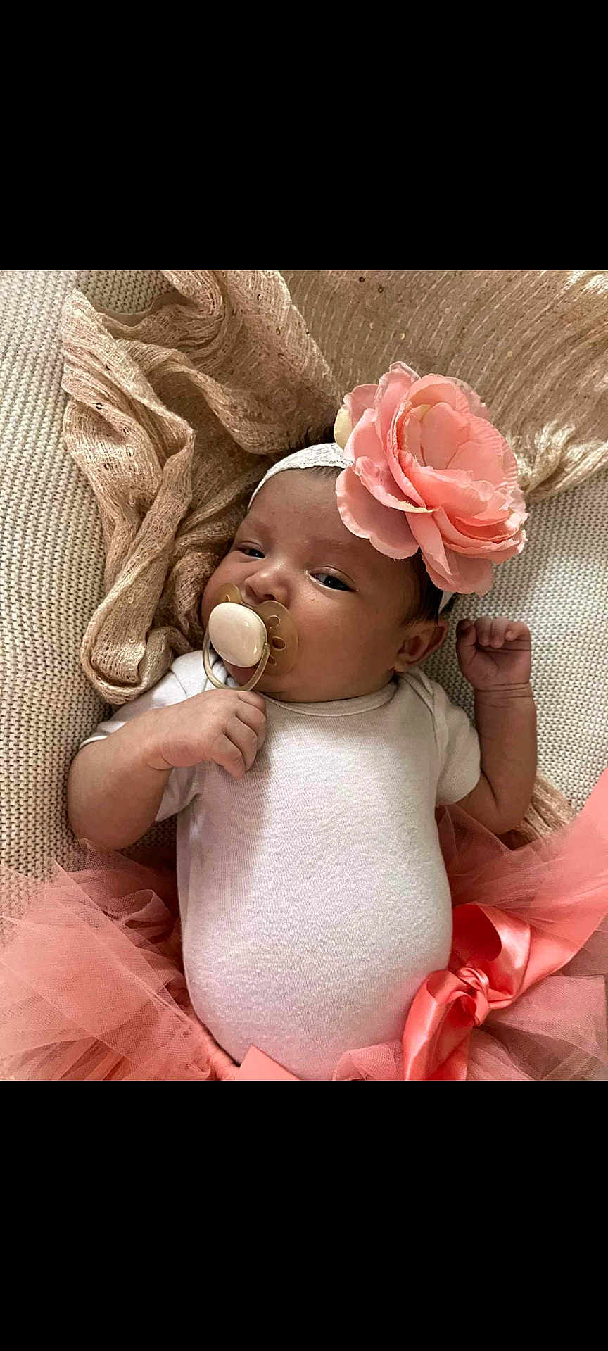 Naomi joined the competition — help win amazing prizes! baby, infant, pacifier, headband, flower, pink, tutu, onesie, blanket, lying_down, cute, newborn, soft_texture, sleepy, hand, portrait, indoors, child, adorable, resting